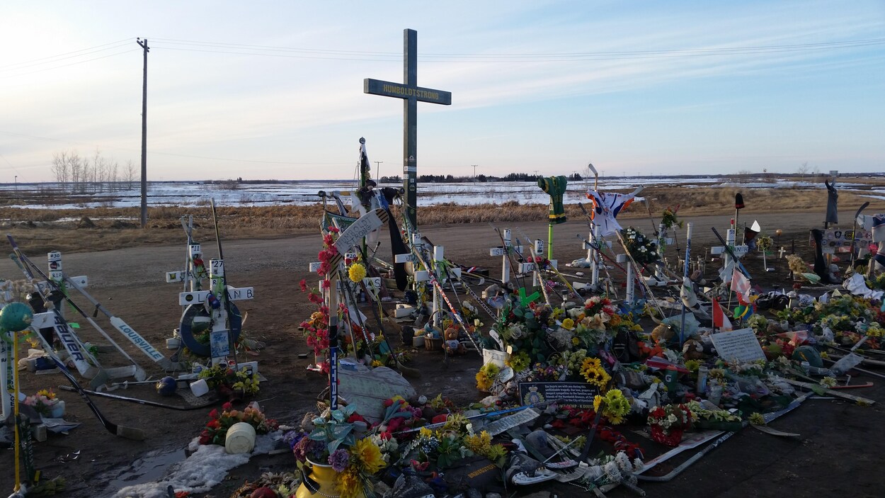 Des fleurs, des lettres et des objets bordent des croix où sont inscrits les noms des victimes. Au centre, sur une grande croix, on peut lire « Humboldt Strong ».
