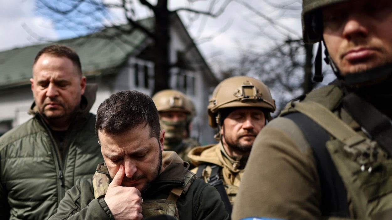 Entouré de soldats, le président ukrainien essuie une larme.
