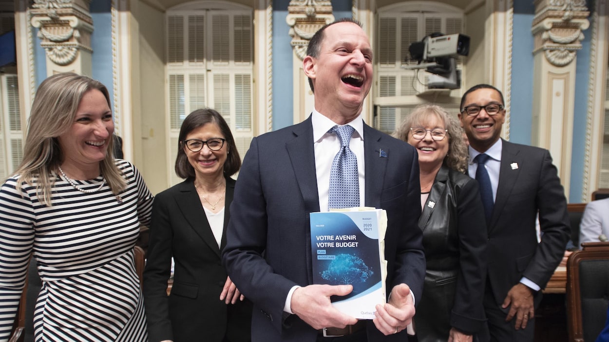Eric Girard est tout sourire entouré d'autres élus de la CAQ.