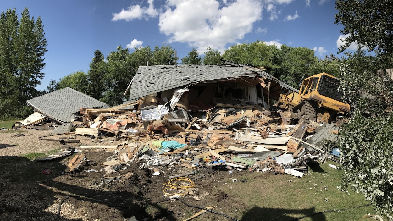 La maison semble avoir été complètement détruite par une tornade, sauf que le bulldozer qui l'a mise à terre se trouve juste à côté. La maison semble avoir été complètement détruite par une tornade, sauf que le bulldozer qui l'a mise à terre se trouve juste à côté.