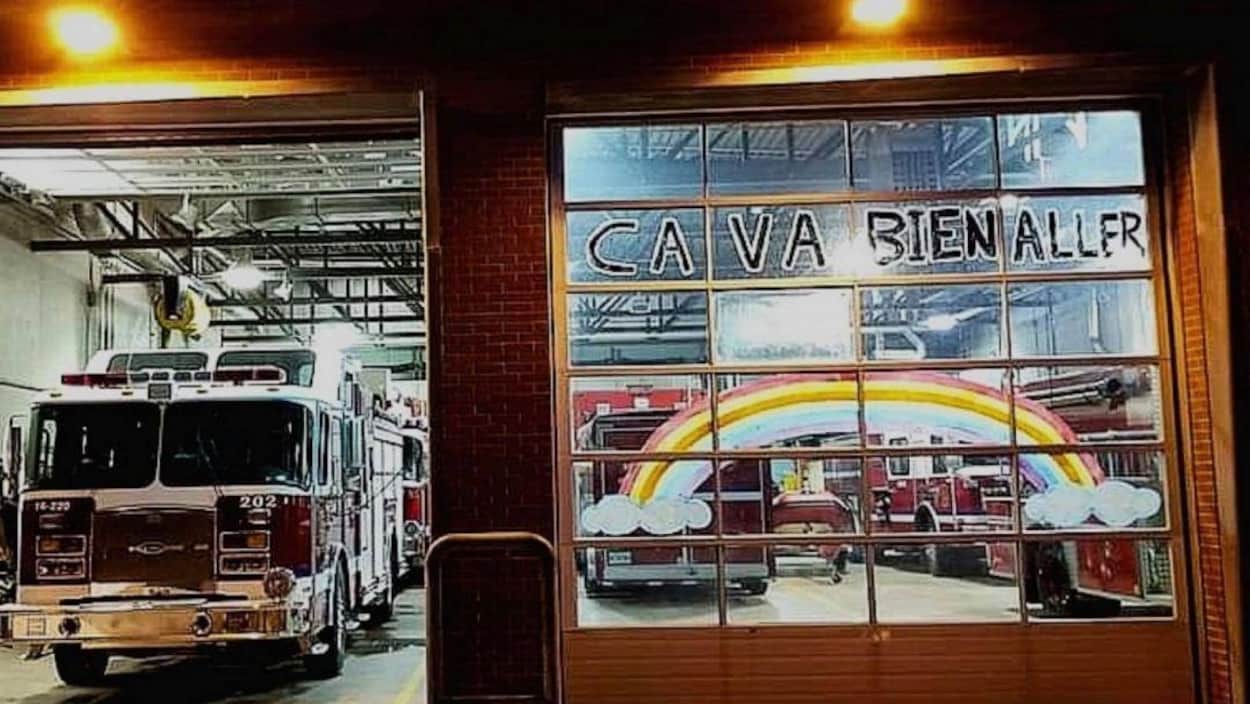 Des dessins d'arcs-en-ciel sur la porte d'une caserne de pompiers.
