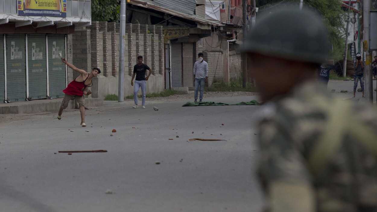 Des manifestants musulmans du Cachemire lancent des pierres sur des soldats indiens pendant le couvre-feu à Srinagar, en Inde, le vendredi 16 août 2019.