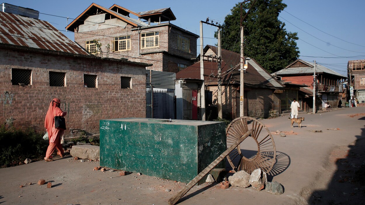 Une Cachemirie passe à côté d'une barrière, à Srinagar.