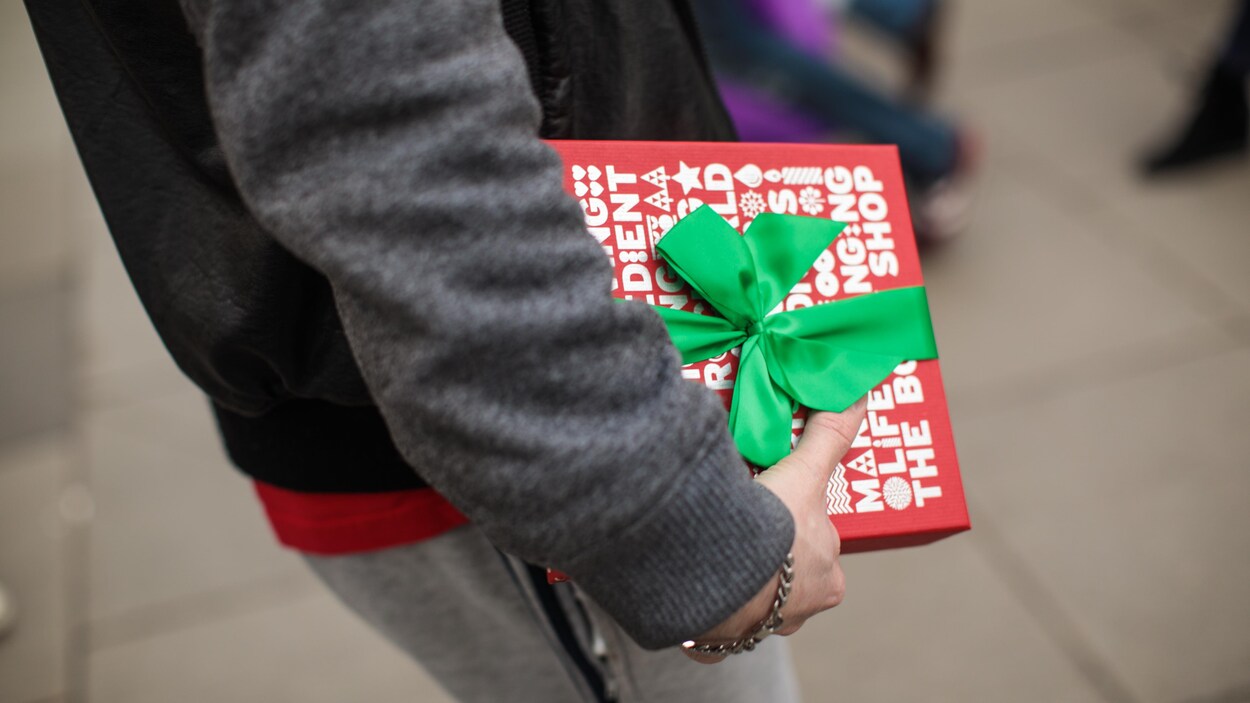 Un consommateur tient son cadeau de Noël.