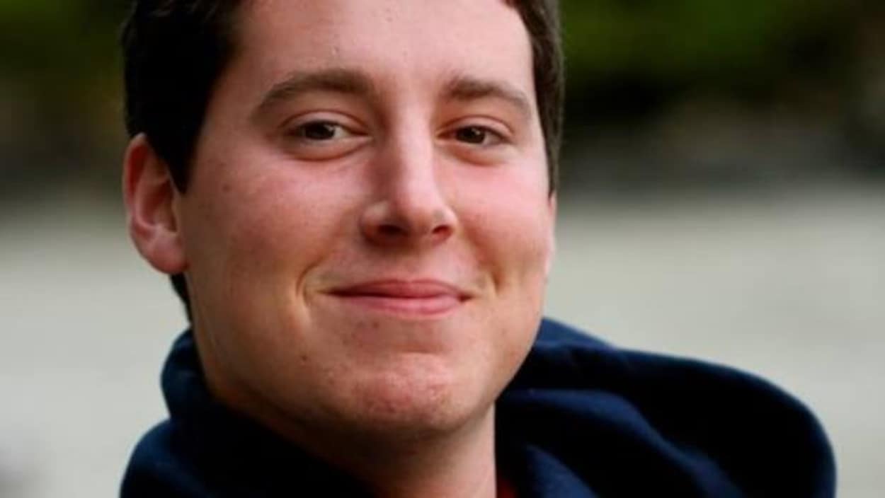 Un jeune homme souriant.