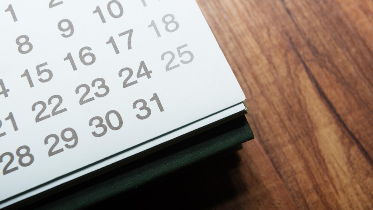 Un calendrier posé sur une table en bois.
