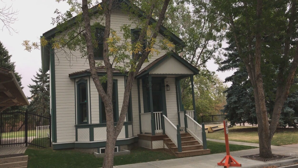 La maison rénovée est verte et blanche et en bon état.