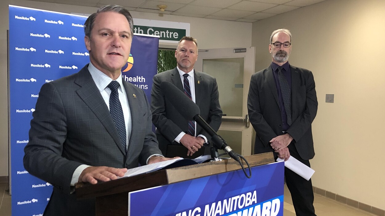 Le ministre de la Santé, Cameron Friesen, devant un micro.