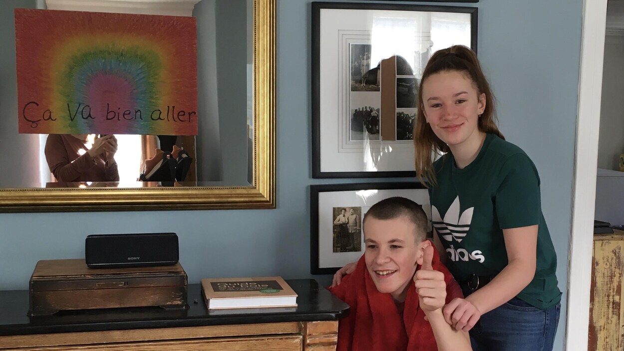 Les deux adolescents ensemble, à côté d'un arc-en-ciel et le slogan « ça va bien aller ».