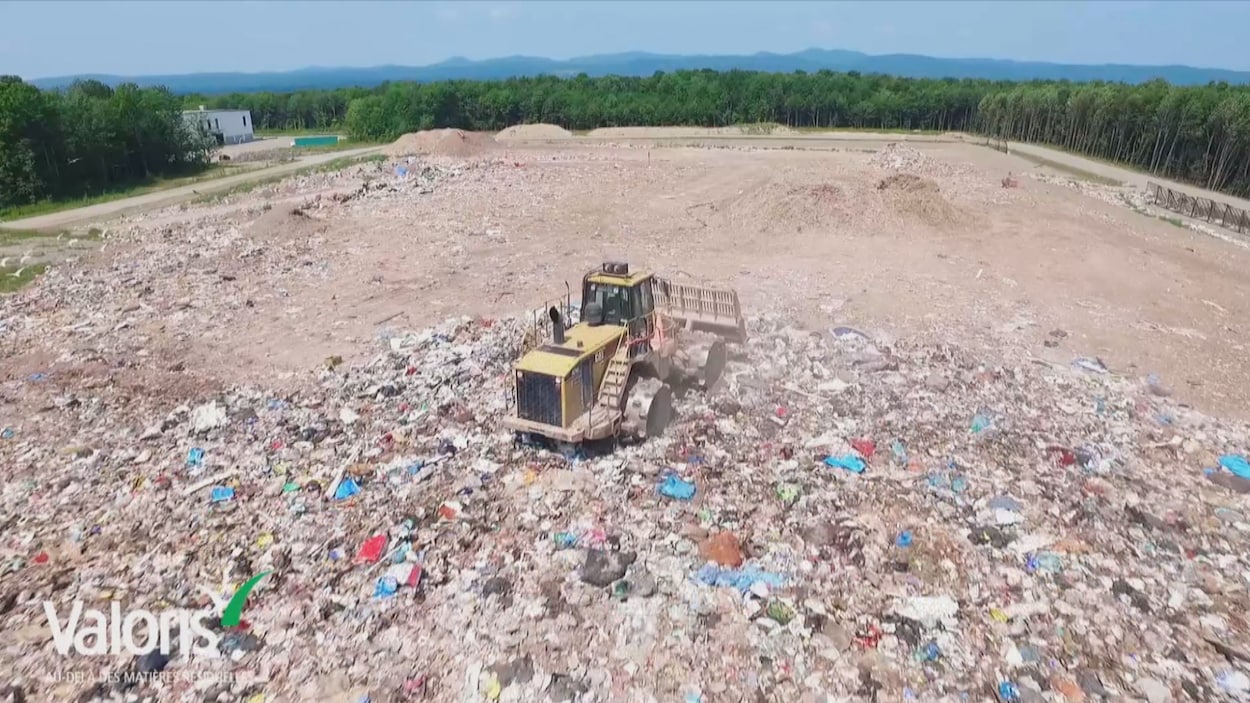 Un camion ensevelit des déchets sous la terre.