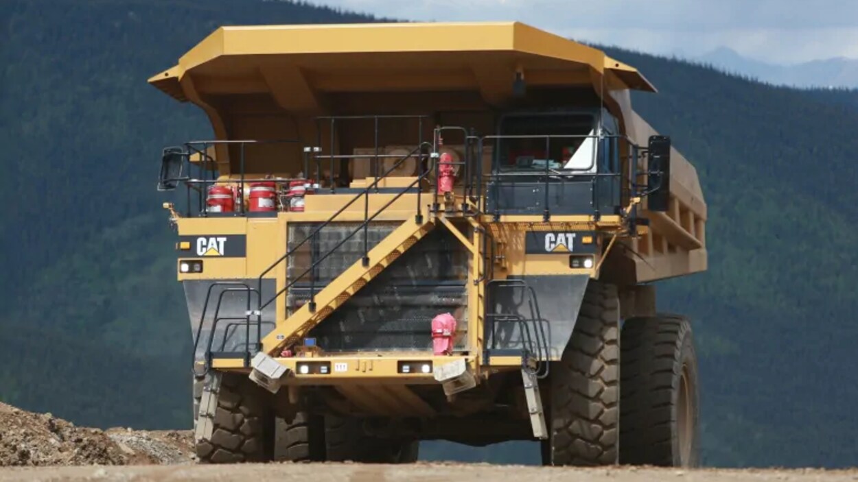 Un énorme camion de la mine Eagle est garé sur un chemin avec, derrière lui, une forêt.