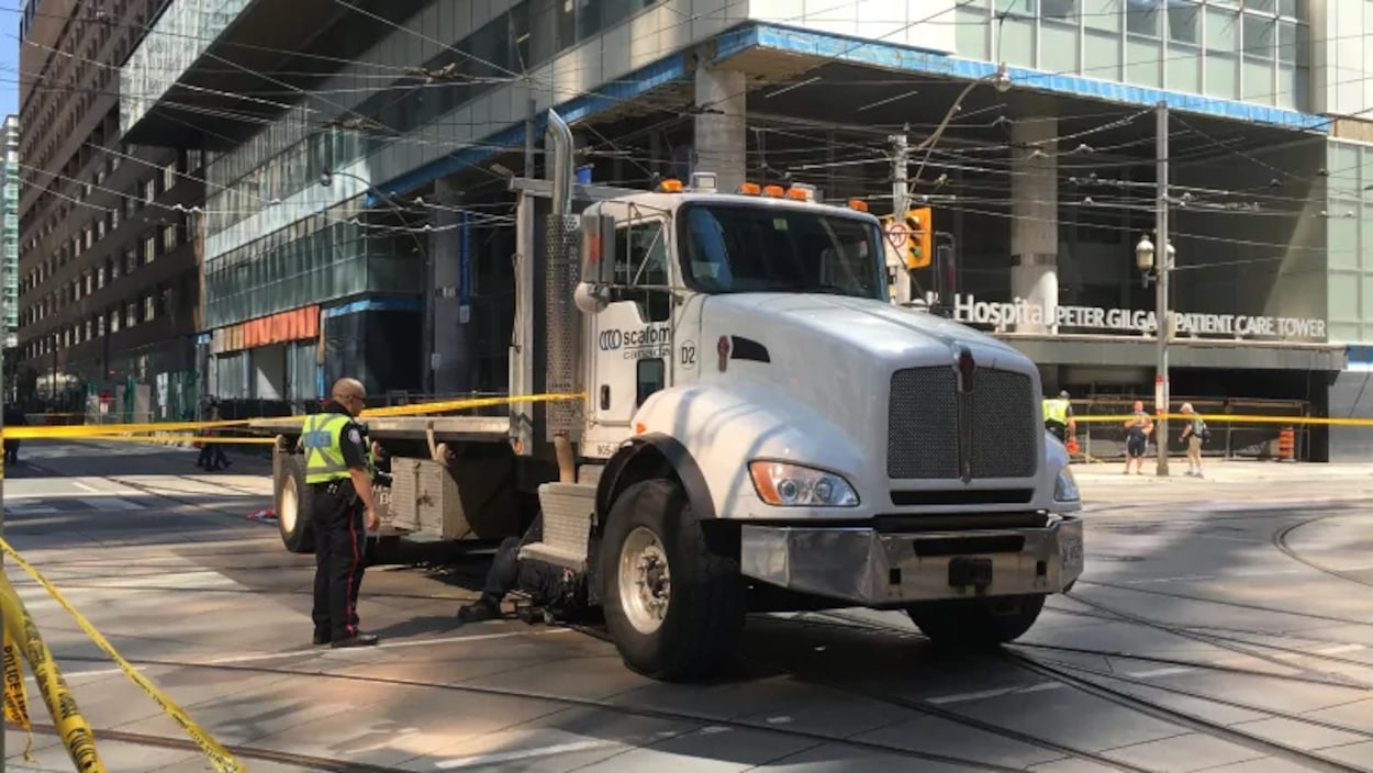 Photo d'un camion blanc immobilisé au milieu d'une intersection, entouré d'une banderole de police jaune.