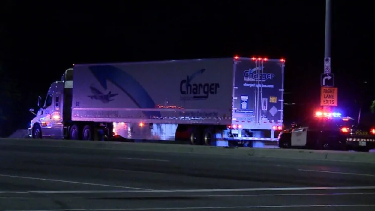 Photo d'un camion immobilisé sur la route la nuit; une autopatrouille aux gyrophares allumés est derrière le camion.