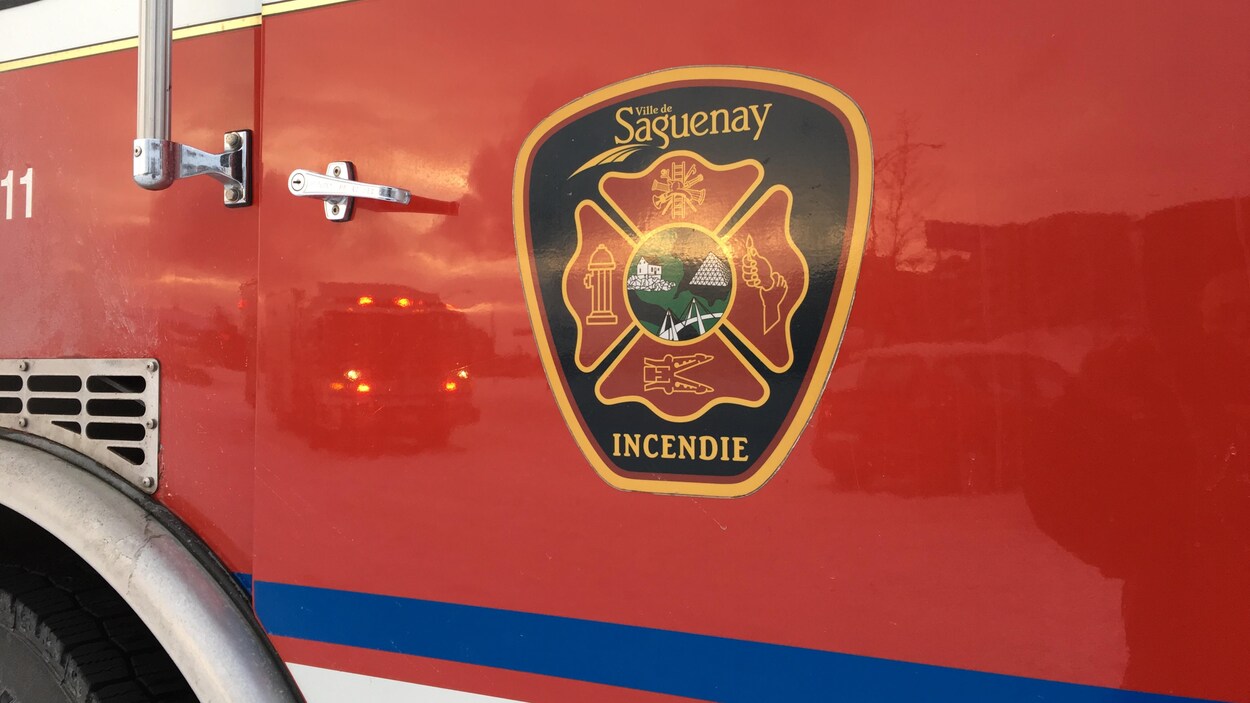Le logo du Service de sécurité incendie de Saguenay apparaît sur la porte d'un camion.