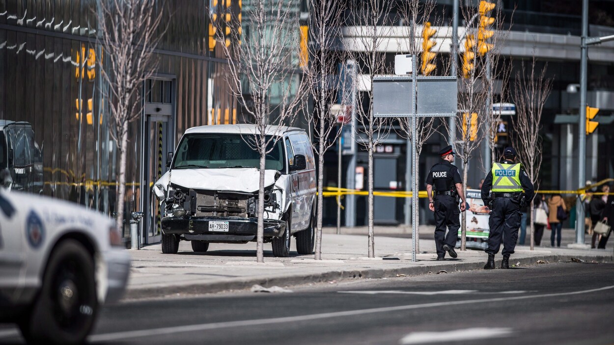 Deux policiers marchent près de la camionnette utilisée par le tueur. Deux policiers marchent près de la camionnette utilisée par le tueur.