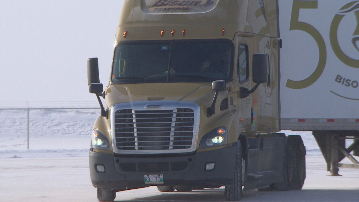 Un camion avance vers la caméra. Il y a de la neige dehors.
