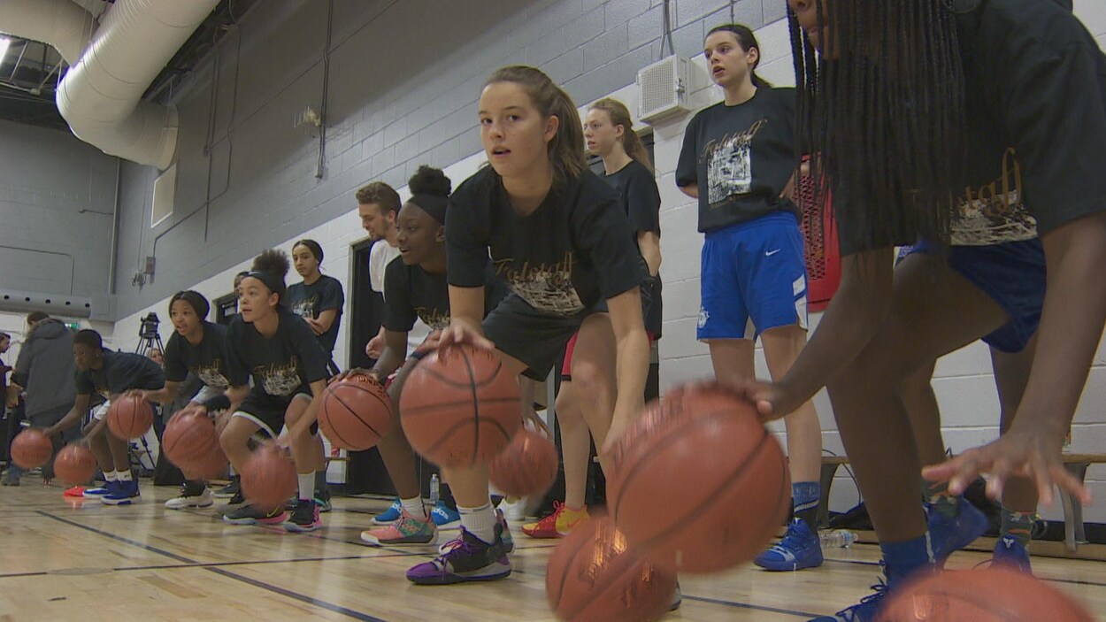 Des adolescentes dribblent sur un terrain de basketball.