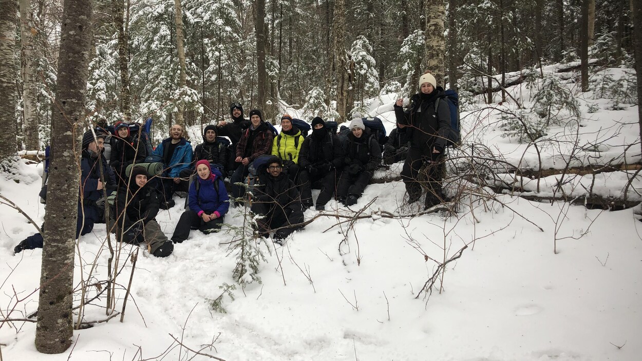Des jeunes se trouvent dans la forêt avec de l'équipement de camping.
