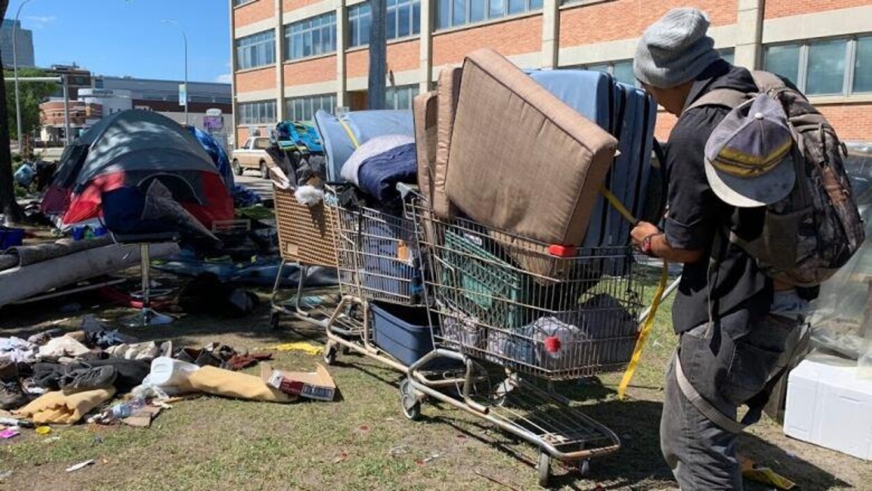 Un sans-abri qui tire un chariot rempli de ses effets.