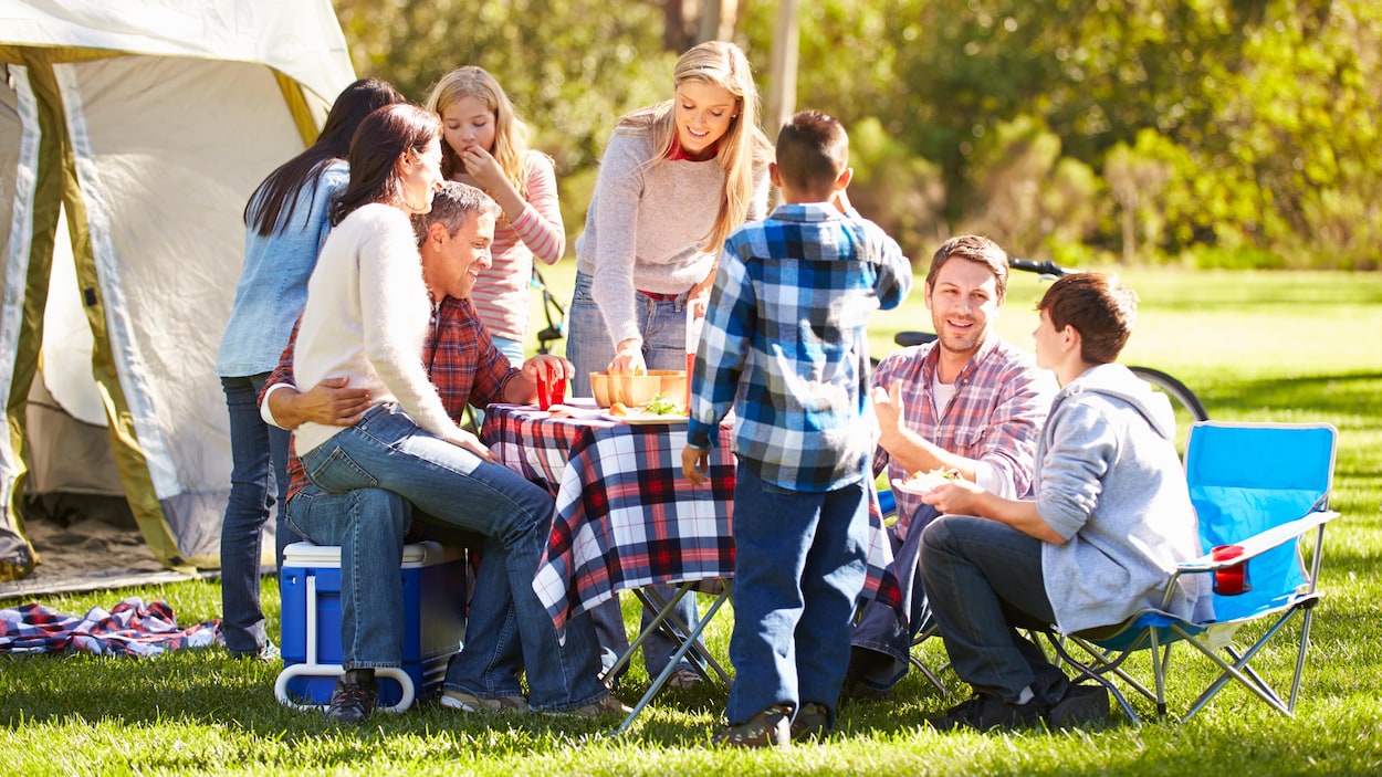 Des amis partagent un repas en camping. Des amis partagent un repas en camping.