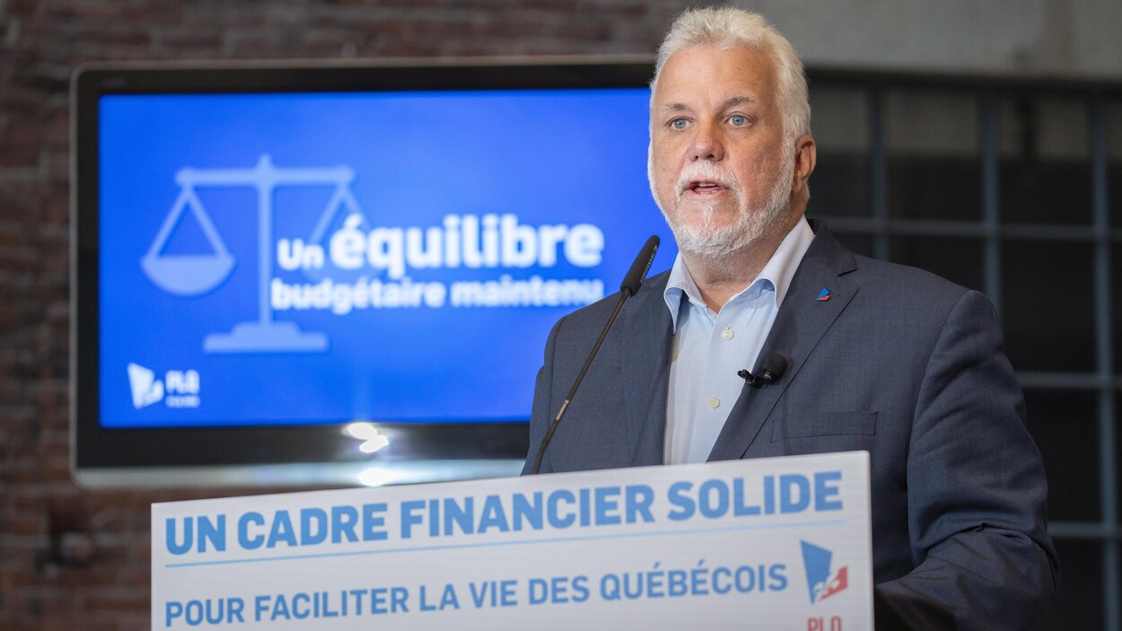 Philippe Couillard devant un lutrin parle dans un micro.