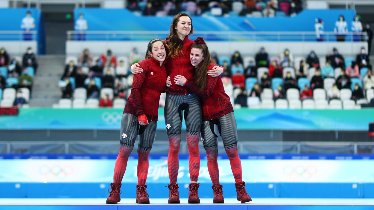 Isabelle Maltais, Isabelle Weidemann et Ivanie Blondin se serrent dans leurs bras sur le podium.