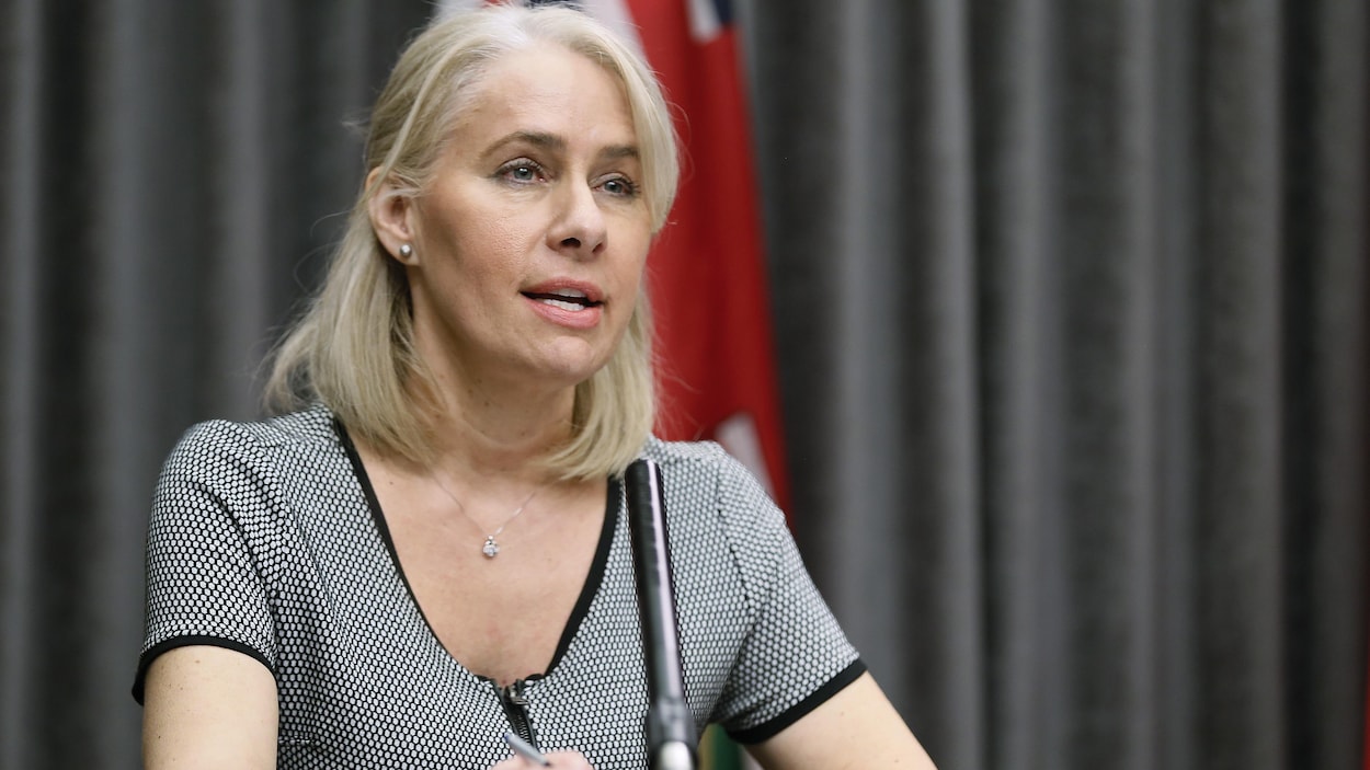 Lanette Siragusa est assise à une table et parle dans un micro devant elle.
