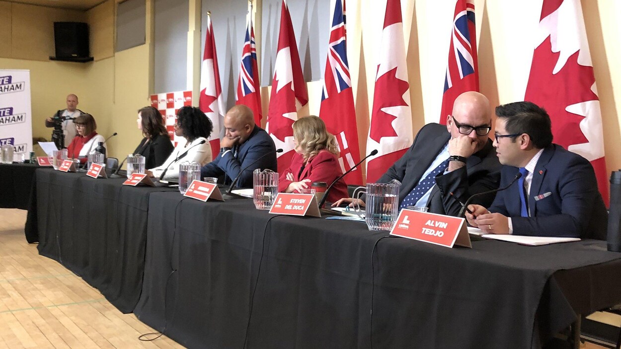 Kate Graham, Mitzie Hunter, Michel Coteau, Brenda Hollingsworth, Steven Del Duca et Alvin Tedjo assis à une table dans une grande salle devant des drapeaux du Canada et de l'Ontario.
