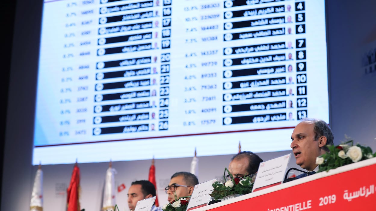 Un homme annonce les résultats du premier tour de la présidentielle tunisienne.