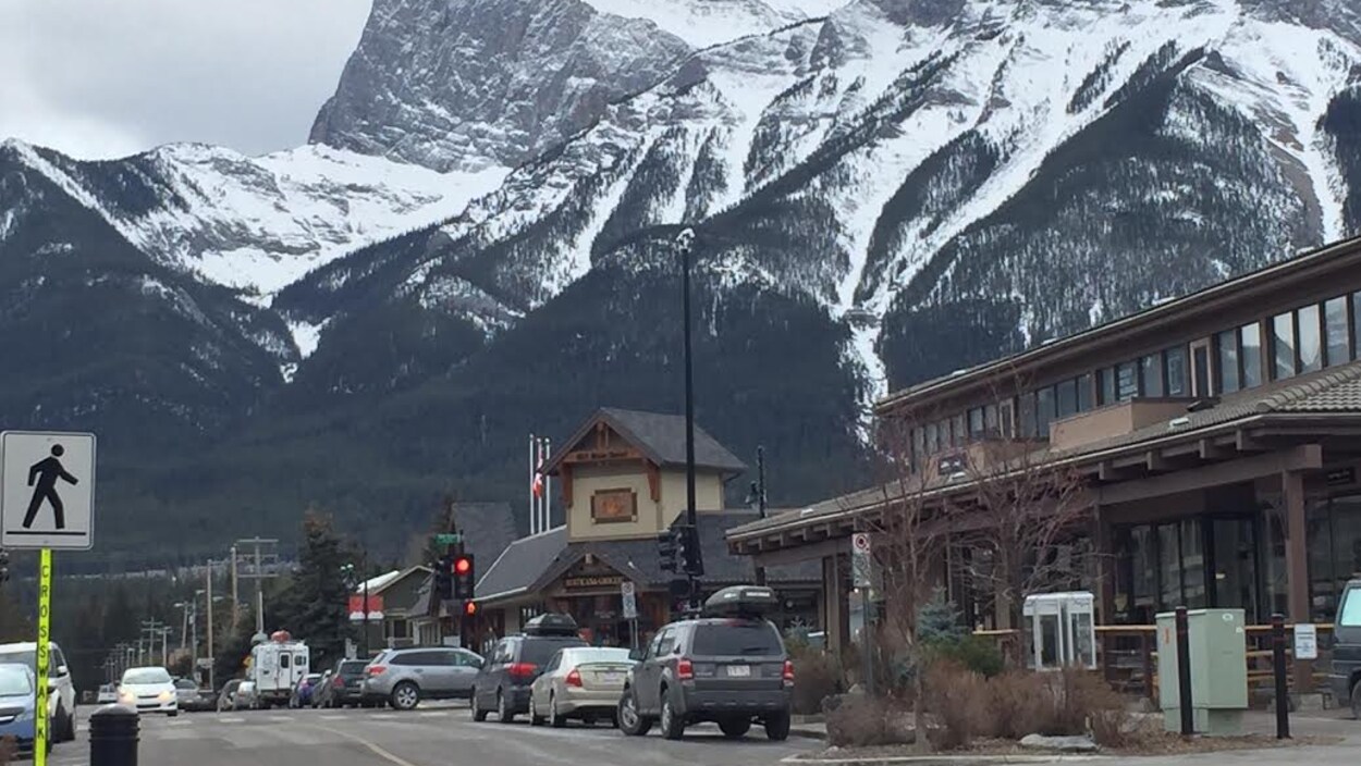 Des voitures stationnées dans une rue du centre-ville de Canmore.