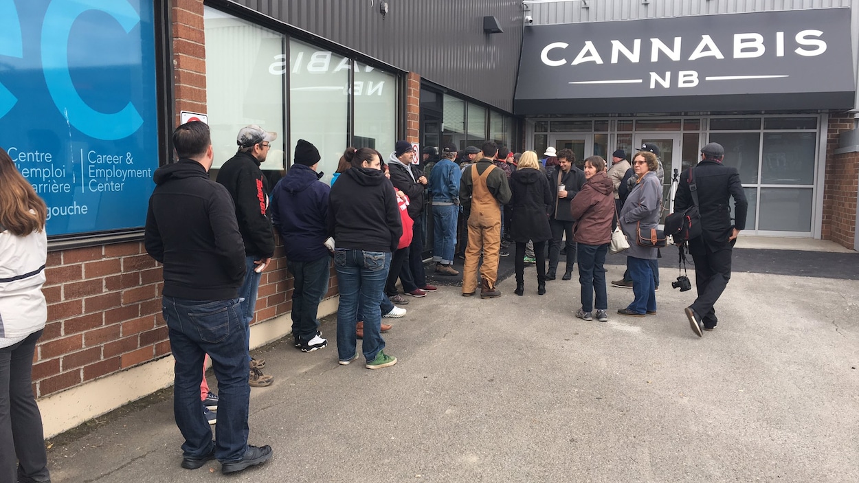 Quelques dizaines de personnes attendent aux portes à l'ouverture du magasin.