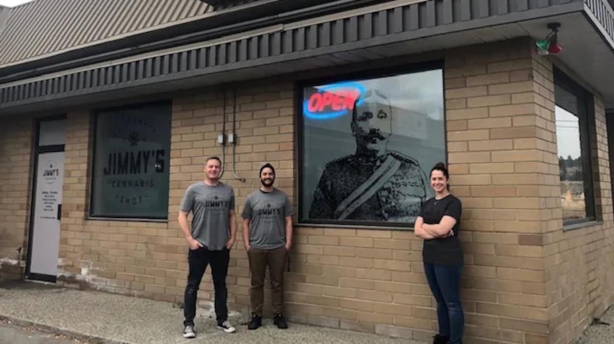 Deux hommes et une femme sont debout devant l'image de Sam Steele à la boutique de cannabis Jimmy's à Cranbrook.