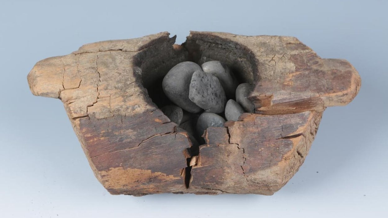 Un contenant de bois avec des pierres à l'intérieur.
