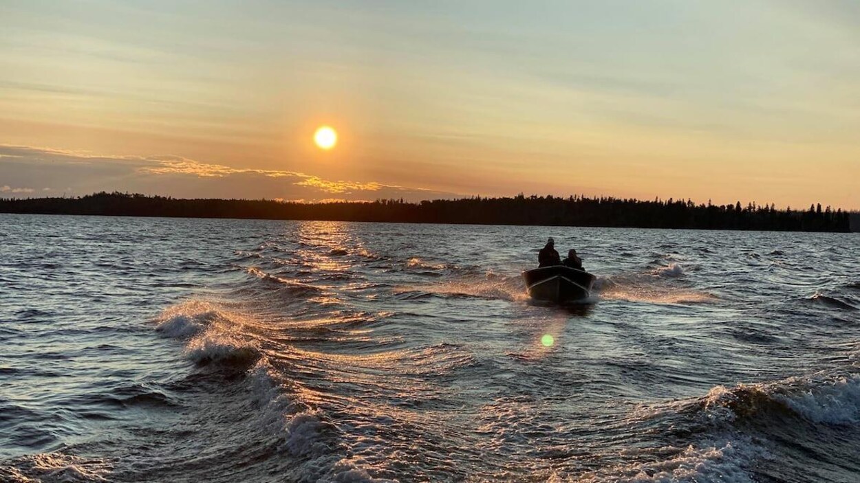 Un bateau sur un lac à l'aurore.