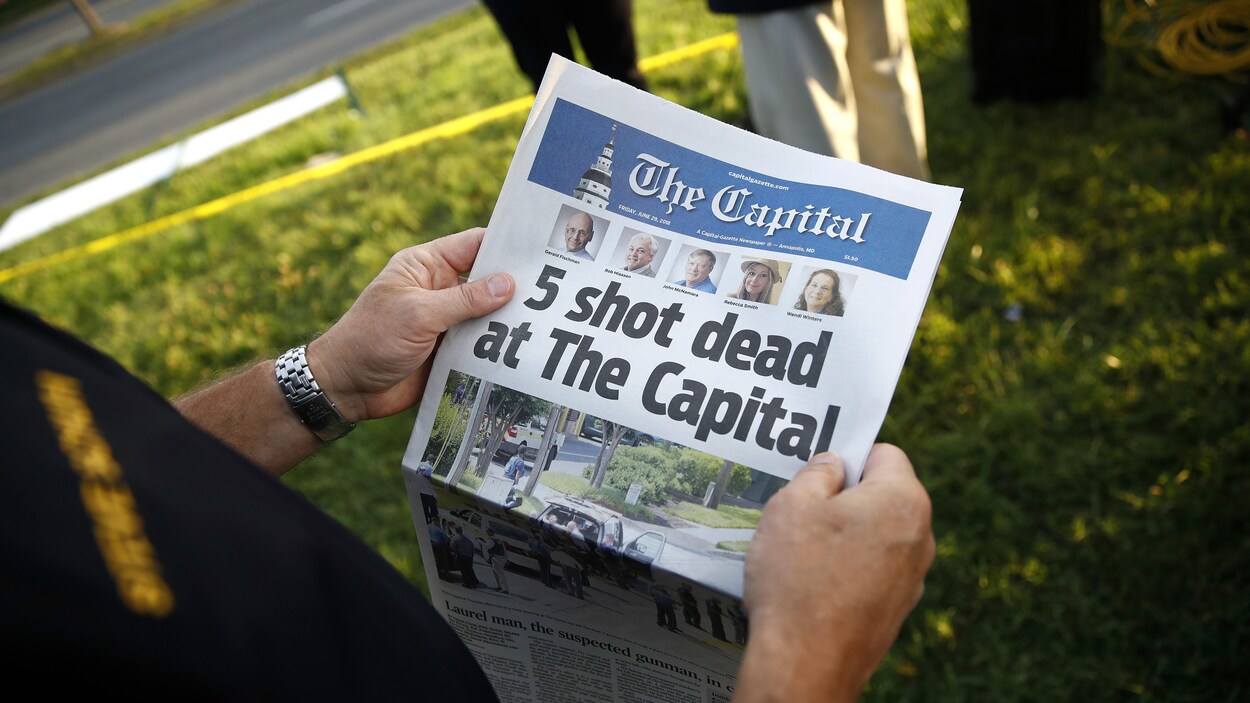 « Cinq personnes tuées par balle au Capital », peut-on lire sur la une du quotidien, qu'un homme tient dans ses mains. 