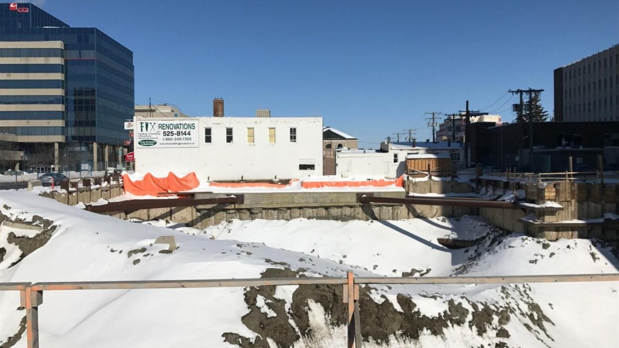 Un chantier de construction dans un centre-ville, sans travailleurs et sous la neige.