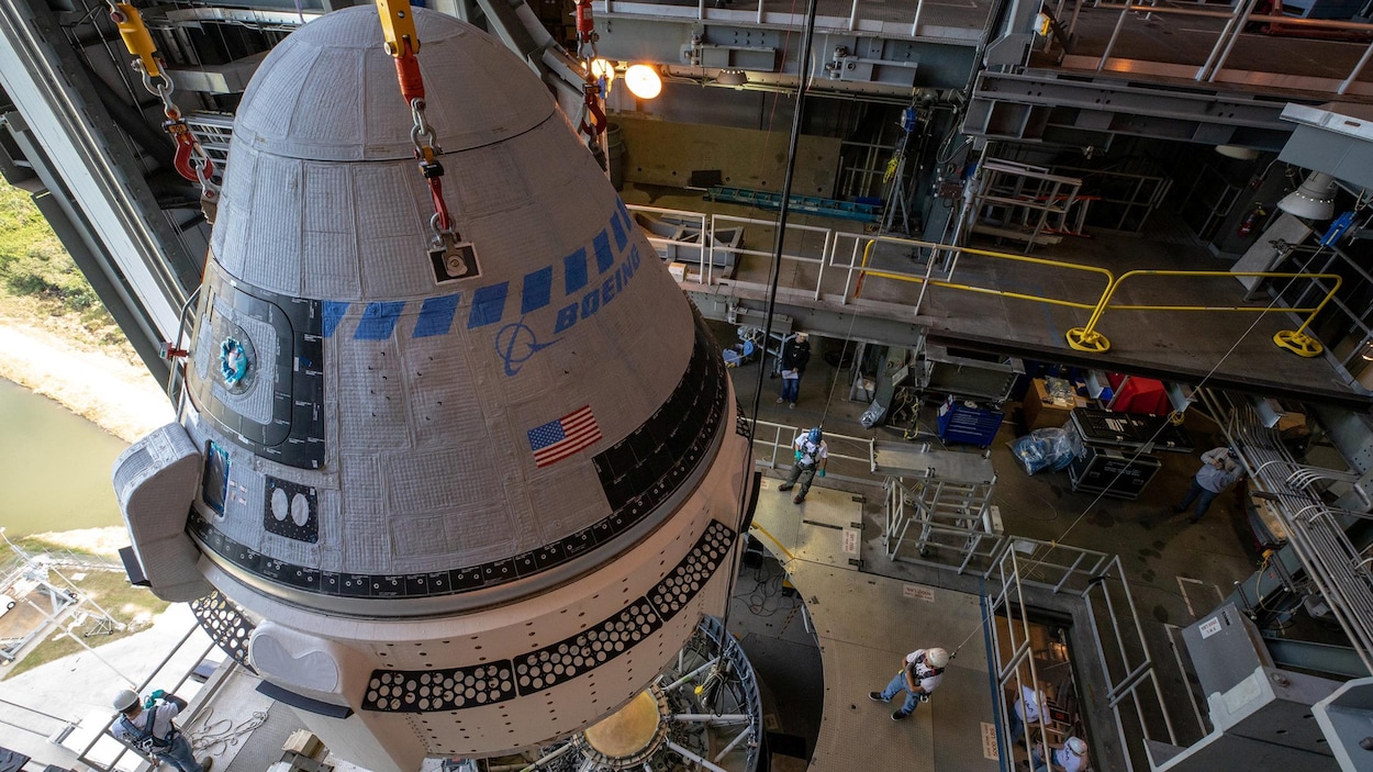 Plan rapproché de la capsule au moment d'être fixée au lanceur.