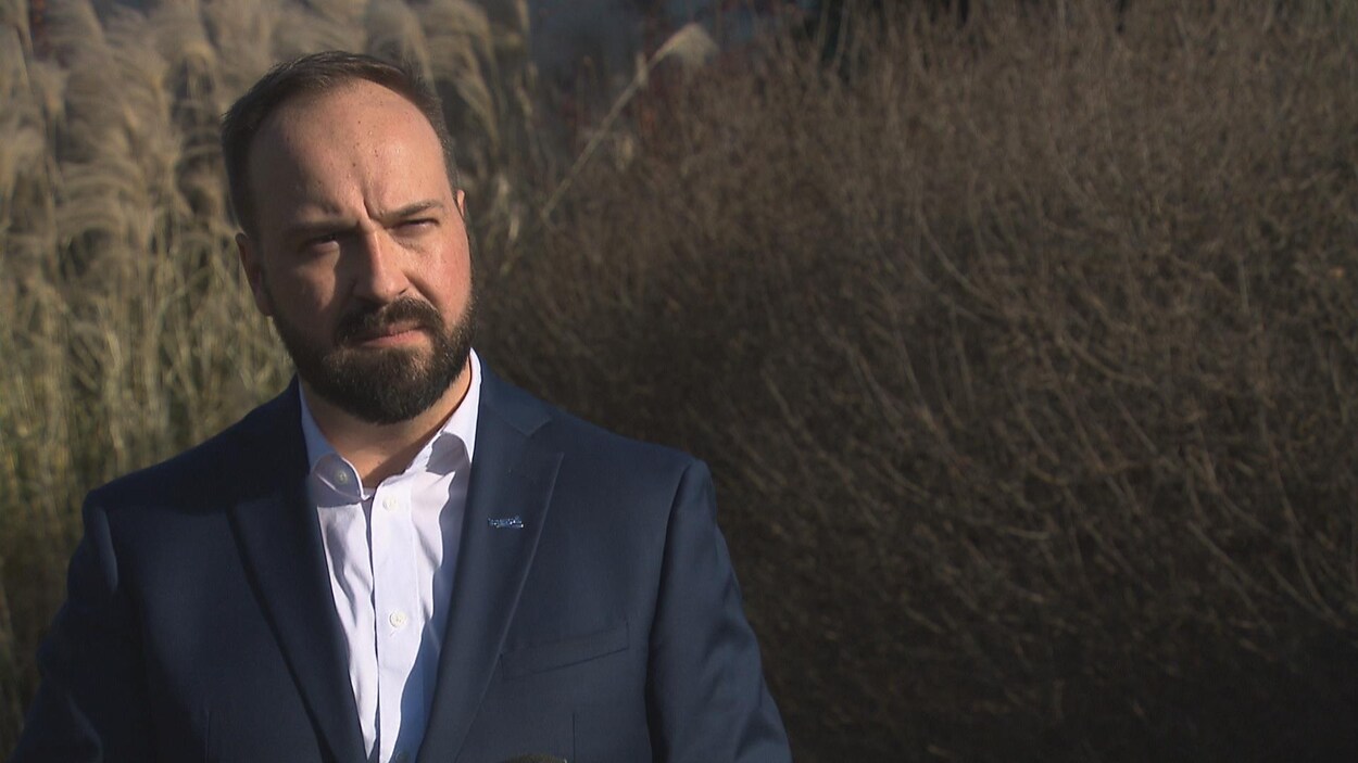 Carl Boisvert devant des arbustes.