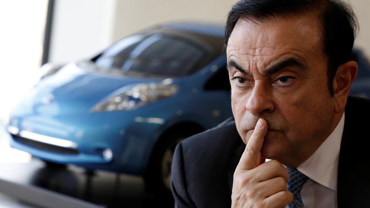 Carlos Ghosn devant une voiture.