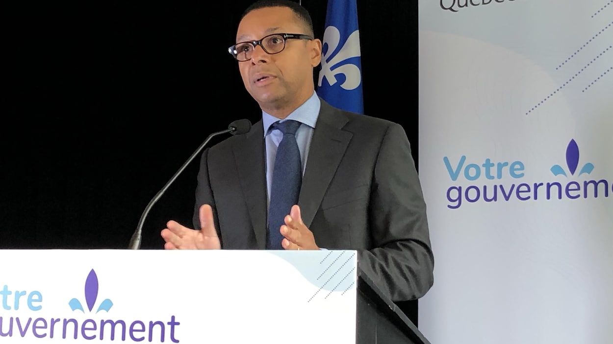 Le ministre Lionel Carmant devant un lutrin.