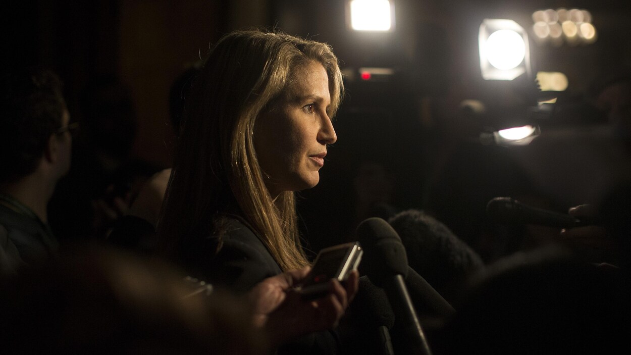 Une femme répond aux questions des journalistes.