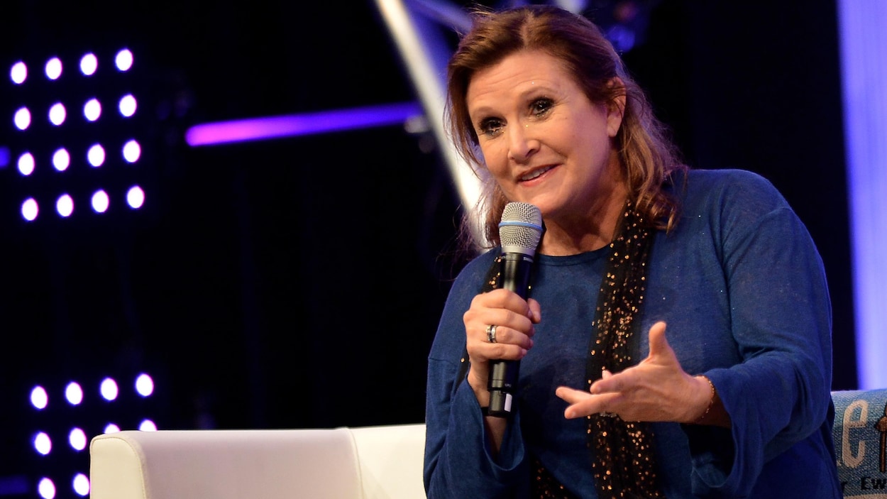 L'actrice Carrie Fisher s'adresse au public, un micro à la main, en juillet 2013. L'actrice Carrie Fisher s'adresse au public, un micro à la main, en juillet 2013.