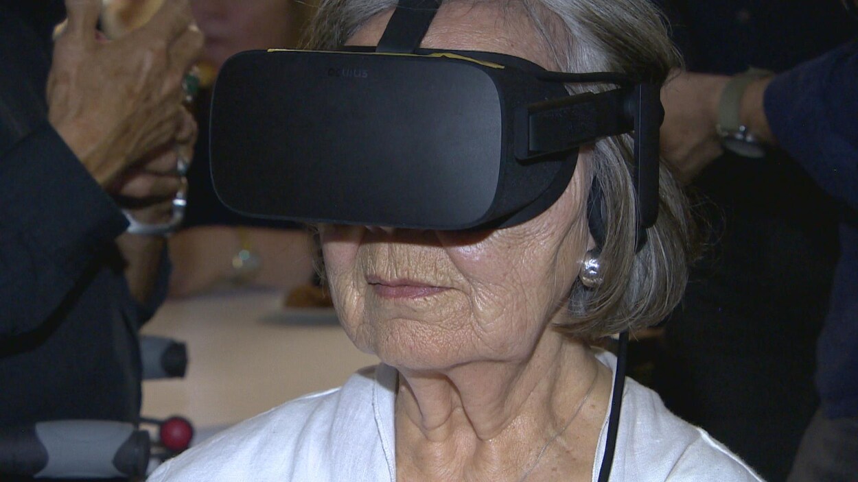 Une femme à la peau ridée porte un casque de réalité virtuelle.