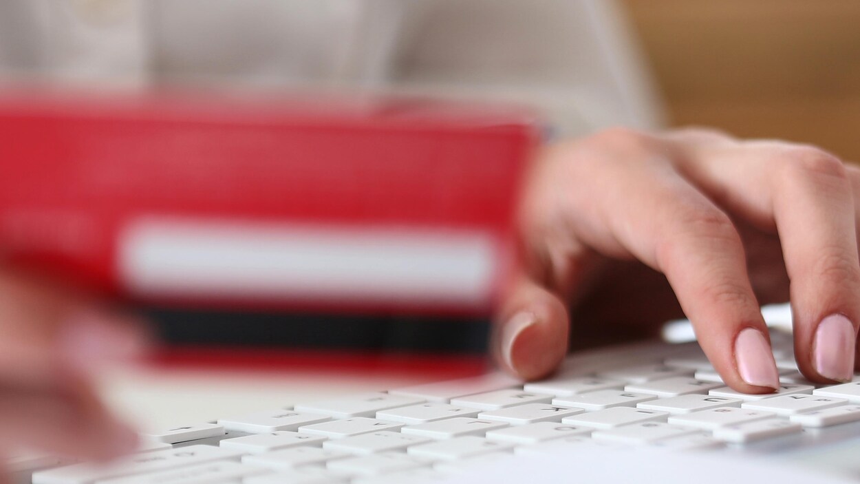 Une femme s'apprête à effectuer un paiement en ligne avec sa carte de crédit. Une femme s'apprête à effectuer un paiement en ligne avec sa carte de crédit.