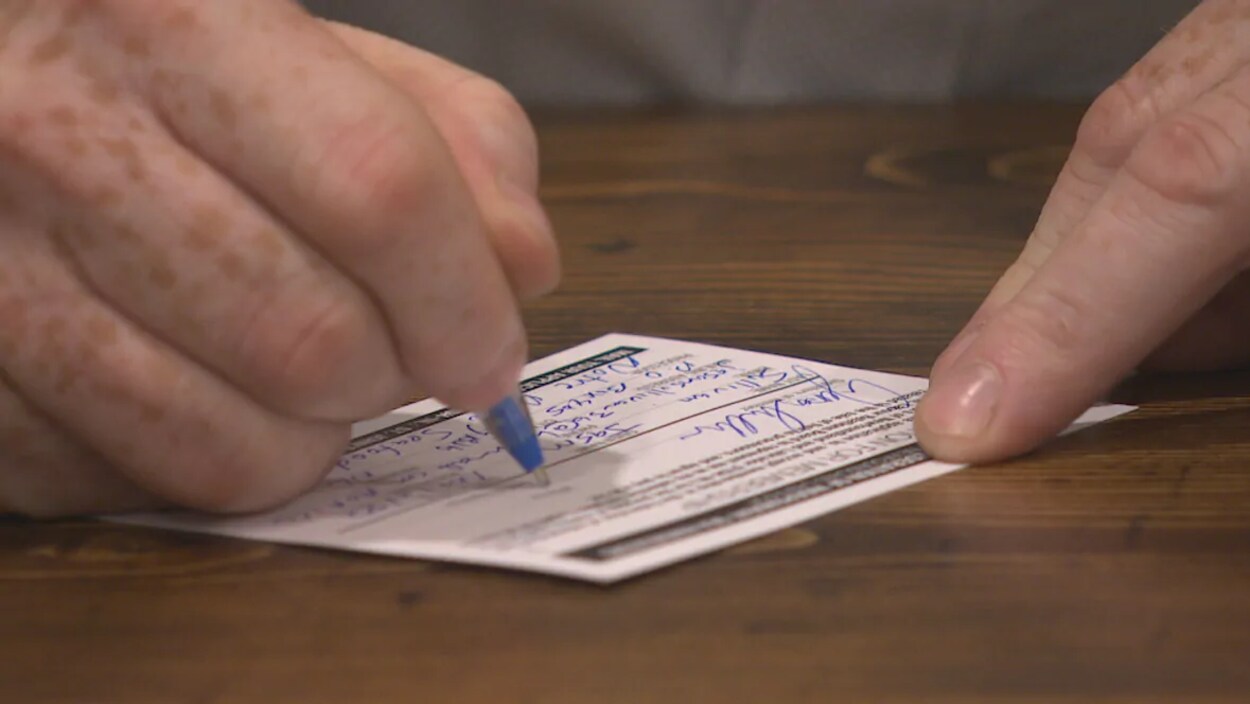 Un membre de FISH-NL signe sa carte de membre.