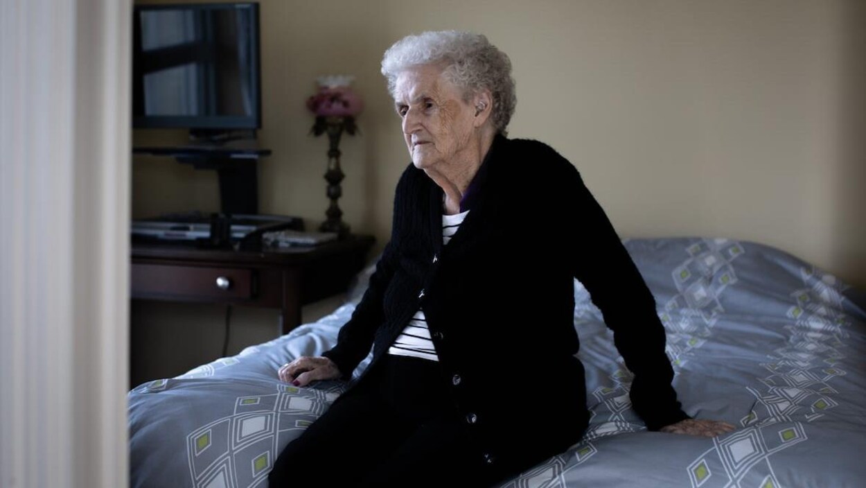Rita Bedford assise sur son lit.