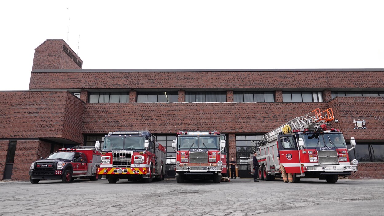 Des camions sont stationnés devant une caserne.
