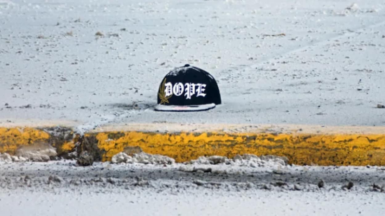 Une casquette de baseball sur un trottoir enneigé.