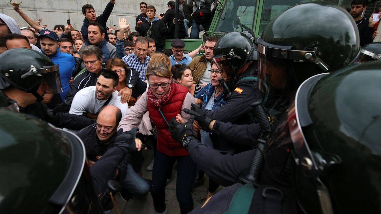 Des agents de la Garde civile espagnole tentent de déloger des Catalans désirant participer au référendum sur l'indépendance.