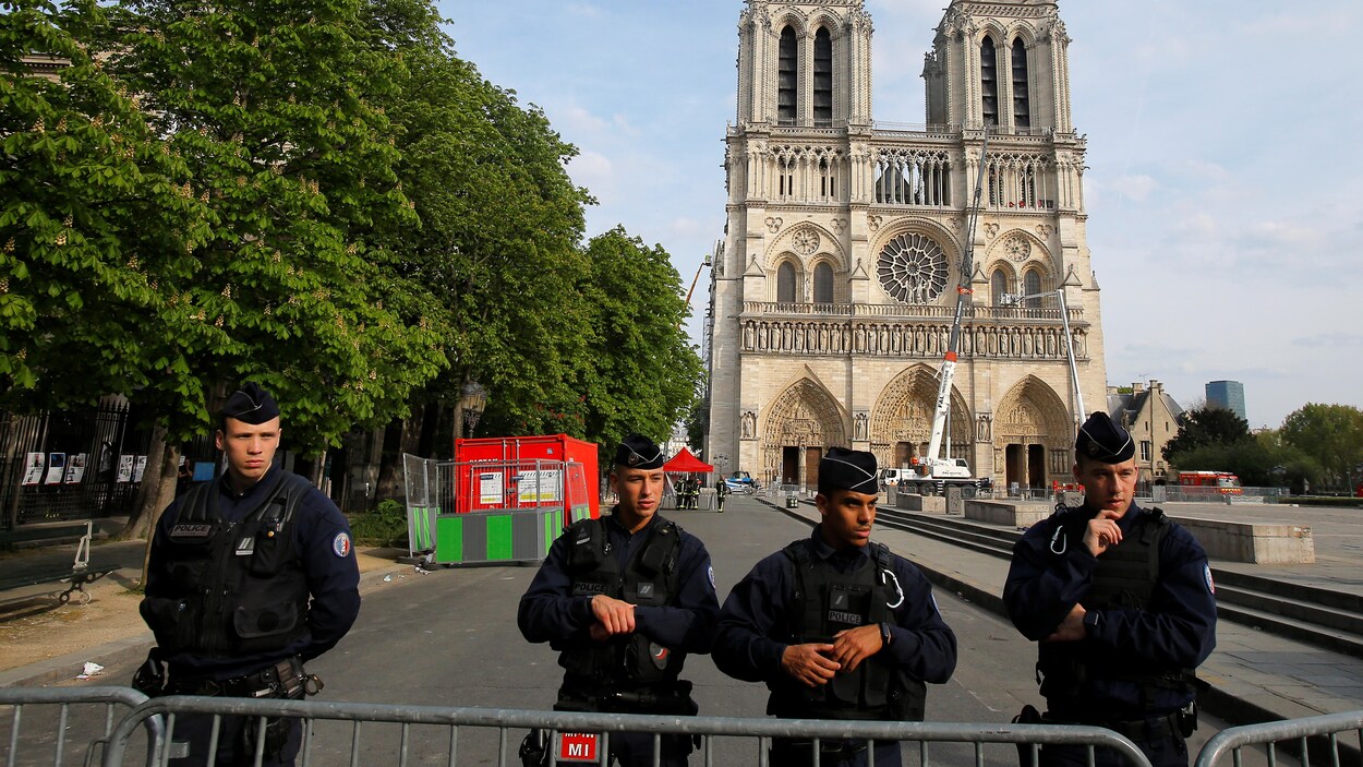 Des policiers se tiennent derrière les barrières de sécurité devant la cathédrale Notre-Dame, à Paris, en France, le 18 avril 2019.